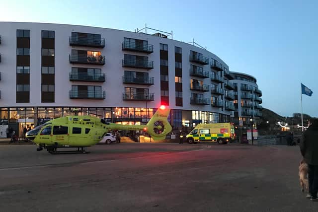The air ambulance and a land ambulance in front of The Sands apartments.