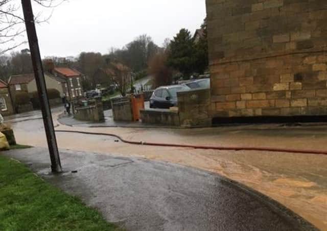 Water is shown pouring down Carr Hill Lane in Briggswath.