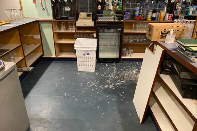 Broken glass and gin bottles left on the floor of the clubhouse.