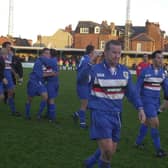 Whitby Town skipper Dave Logan leads his side off after a memorable FA Cup win for the Blues against rivals Scarborough FC in 2001/02