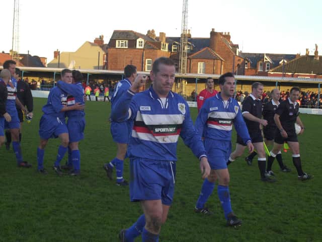 Whitby Town skipper Dave Logan leads his side off after a memorable FA Cup win for the Blues against rivals Scarborough FC in 2001/02