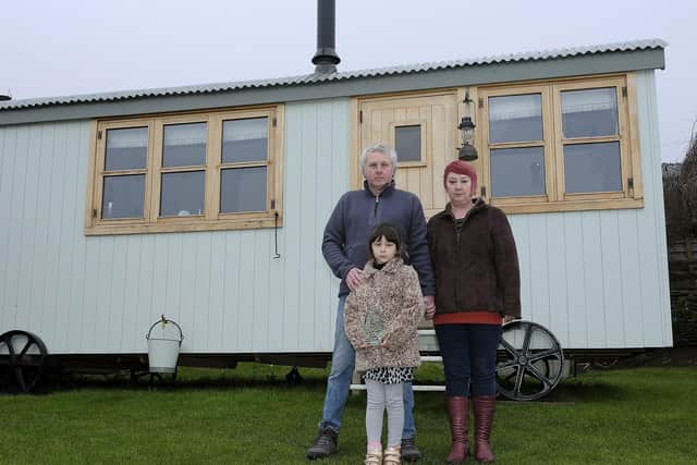 Martin and Paula Goodrick, with daughter Katy, outside their shepherds hut.