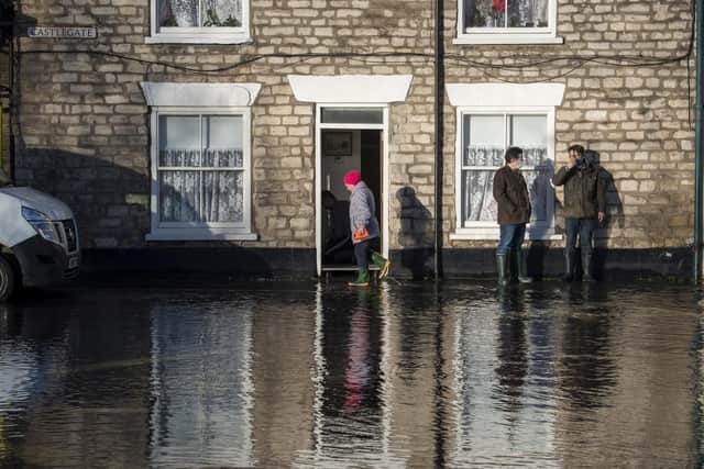 Residents on Castlegate watch the flood water outside their properties in Malton.