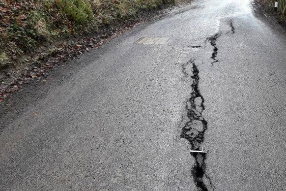 Cracks have appeared on the surface of the road following a landslip.