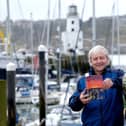 Fred Normandale with his latest book Low Water in Scarborough harbour. Picture: JPI Media/ Richard Ponter