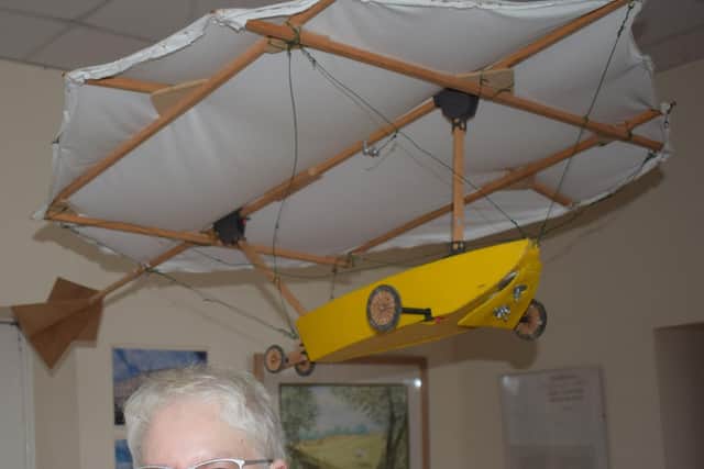Mary Jones with a model replica of Cayley's flying machine.