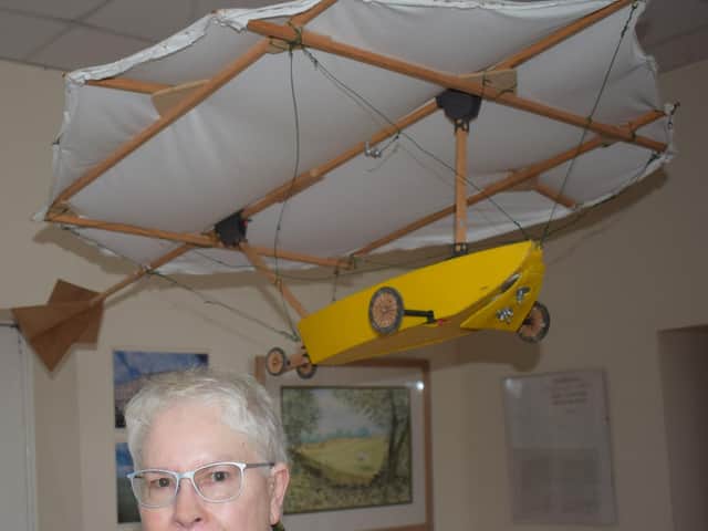 Mary Jones with a model replica of Cayley's flying machine.
