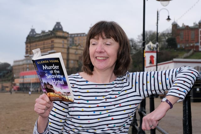 Glenda Young at South Bay beach with the first in the series of cosy crime books set in Scarborough