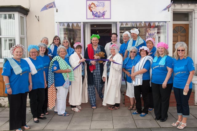 Coastal Voices choir members, Carol Raines and Diane Burbidge look on as Andrew Aldis, general manager at The Bridlington Spa, cuts the ribbon at Happy Bathdays on West Street in 2014. (nbfp-msh1435x423)