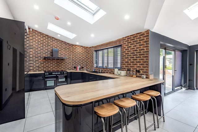 An open brick wall is a feature within this sleek and stylish kitchen.