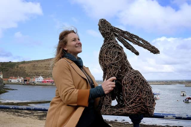 Whitby sculptor Emma Stothard with one of her sculptures on Staithes seafront.
194425b