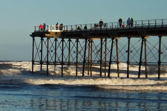 Folks enjoying an amble along Saltburn Pier.