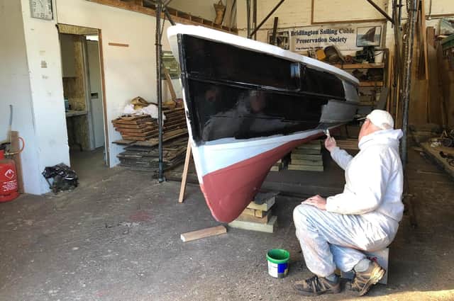 The coble Venus is given a new coat of paint.