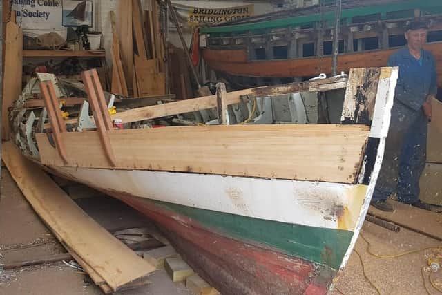 The first plank is placed on the coble.
