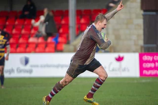 Aaron Wilson with his arm In the air after stealing the ball and running clear for a try

Photos by Andy Standing