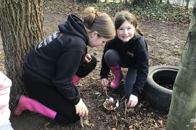 Emmie and Mia lighting a fire at forest school.