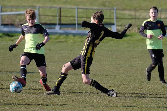 Scalby U13s slide in against Hunmanby U12s, green kit
Photos by Richard Ponter