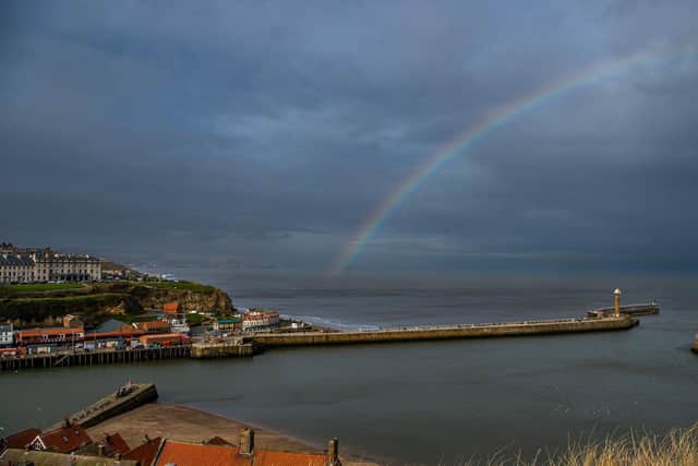 A huge rainbow stretching over Whitby's harbour walls brightens up the day,
