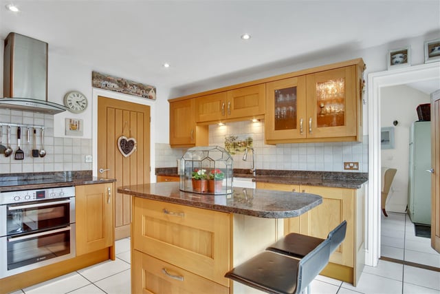 A well equipped kitchen with central island and breakfast bar