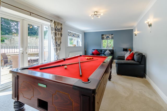This games room with sitting room has doors leading outside, and could be adapted to any number of uses.