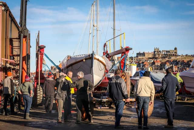 The old lifeboat, Robert and Ellen Robson, is lowered onto the restored carriage at Coates Marine, Whitby.