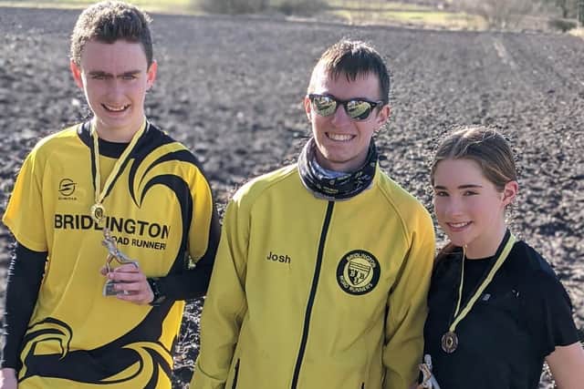 Winners Ben Edwards, left, and Becky Miller, show off their medals and trophies after winning the Bridlington Road Runners Junior Winter Cross Country League after the race at Boynton, with coach Josh Taylor pictured in the middle.