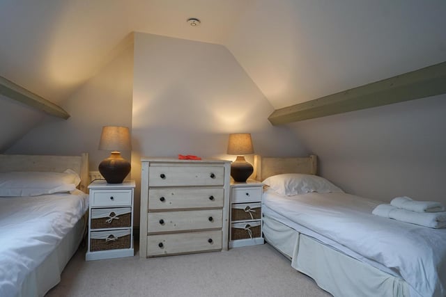 This bedroom has twin beds, with space for free standing furniture