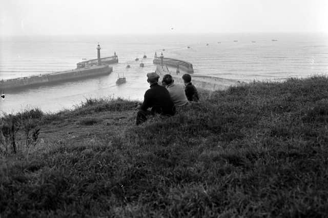 John Tindale's photo of a family watching herring boats leaving Whitby.
