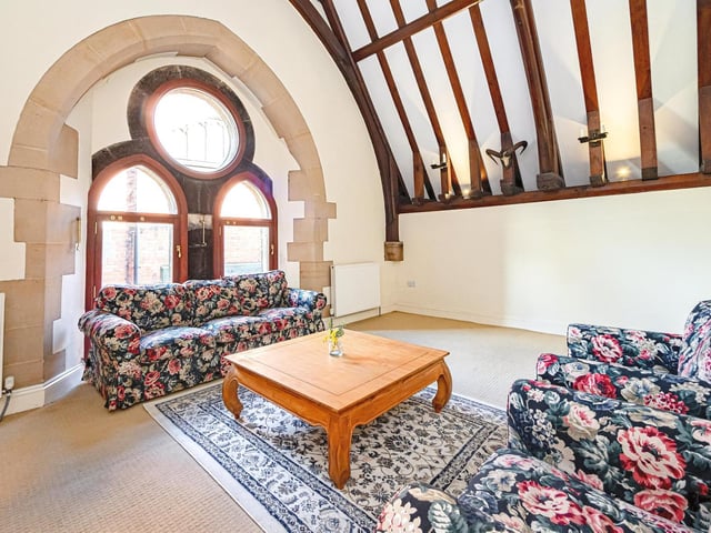 This sitting room is flooded with natural light from the large feature windows.