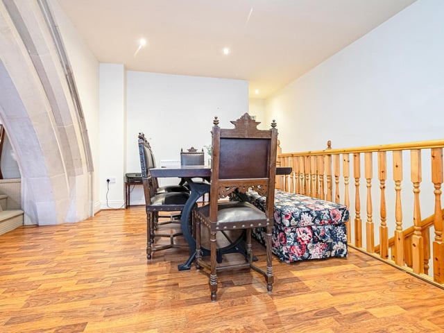 A wide stone arch links the dining area and living room within the property.