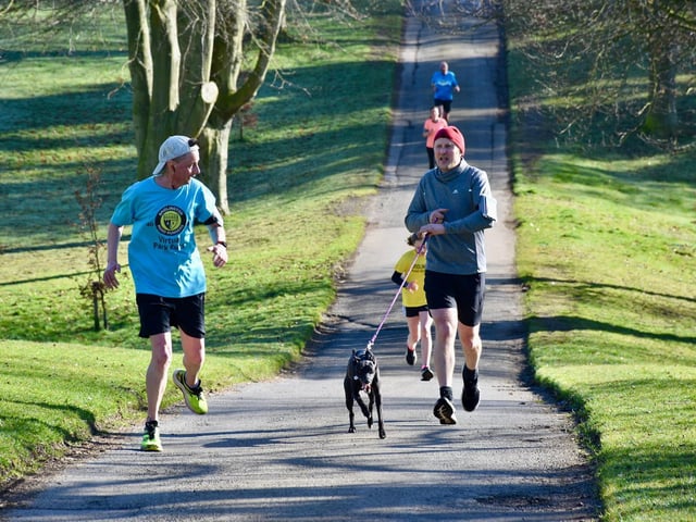A runner keeps a close eye on a dog at Sewerby Parkrun