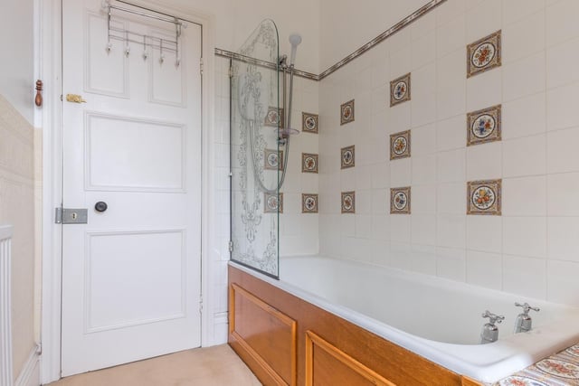 An over bath shower is fitted in this house facility with decorative tiles.