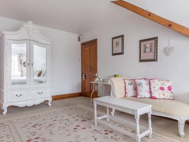 An elegant bedroom with beams on the second floor.