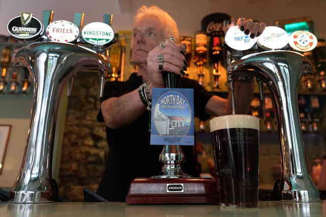 Landlord and owner Keith Dufton pulls a pint behind the new bar.