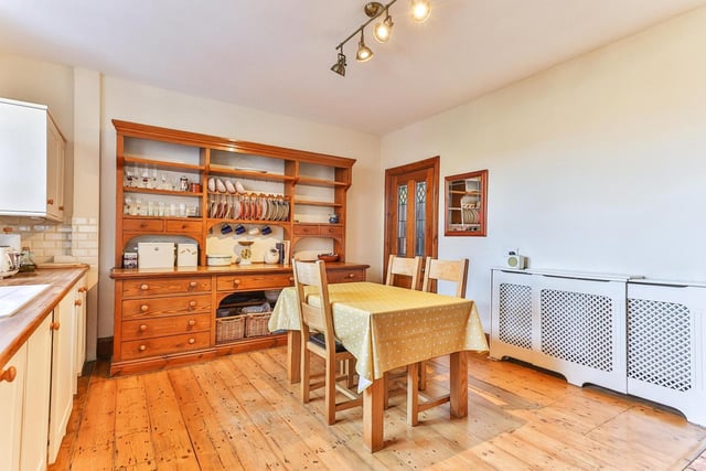This roomy kitchen has fitted units with wooden work tops, and a large window.