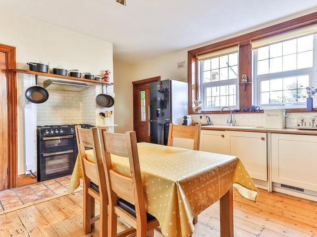 An alternative view of the dining kitchen showing its window and the wall with space for a range style cooker.