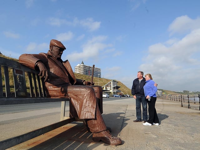 Freddie Gilroy sits on a bench facing the North Sea in Scarborough’s North Bay. He is wrapped up in an overcoat, a cloth cap pulled down, a walking stick in one hand and the other arm draped across the bench.
He is a giant steel sculpture created by Ray Lonsdale. Freddie Gilroy was a 23-year old miner and one of the first soldier to relieve the Bergen-Belsen concentration camp at the end of the Second World War.