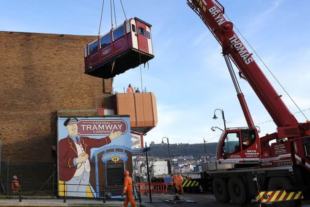 A crane lifts out the tramway carriages one by one, so that they can be taken away for refurbishment.