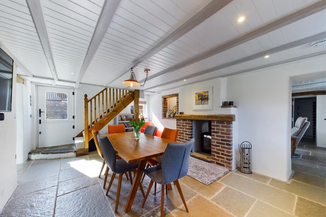 A fireplace and open staircase are features of this room which has enough space for a large dining table and chairs.