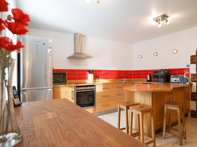 Hand-made units in light oak are a feature of this bright and welcoming kitchen.