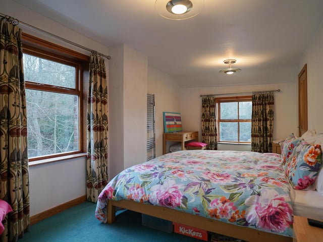 A spacious bedroom with large windows allowing plenty of natural light.