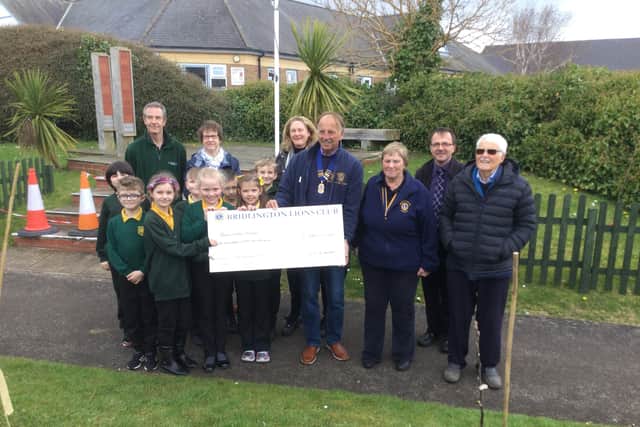 Bridlington Lions president Gary Hughes presents the cheque for £150 to Burlington Junior School pupils. Photo submitted