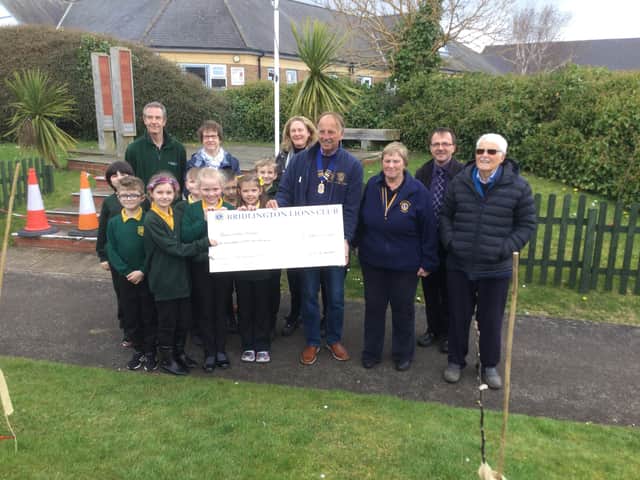 Bridlington Lions president Gary Hughes presents the cheque for £150 to Burlington Junior School pupils. Photo submitted