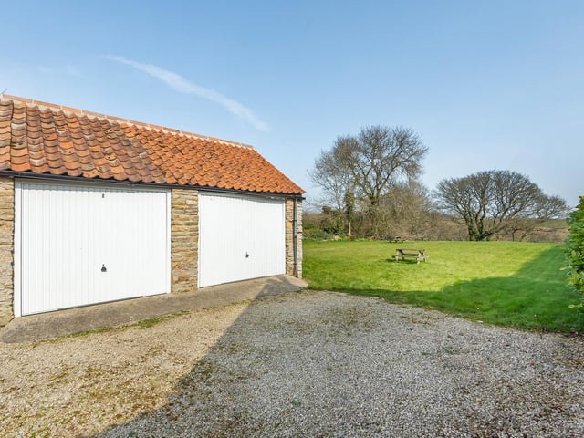 The double garage is adjacent to the large garden area.