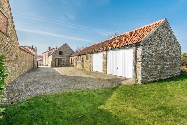 The property has a double garage and outbuildings included in the sale.