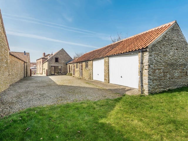 The property has a double garage and outbuildings included in the sale.