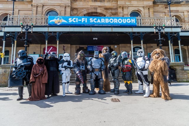 A Mandalorian, a Jawa, Kylo Ren, a Stormtrooper commander, a Big Daddy from Bioshock, Armoured Batman, Chewbacca, Master Chief from Halo, Boba Fett and a biker scout from Star Wars, and another Wookiee gather outside Scarborough Spa.