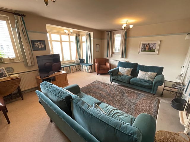 A central fireplace and large windows are features of this comfortable room.