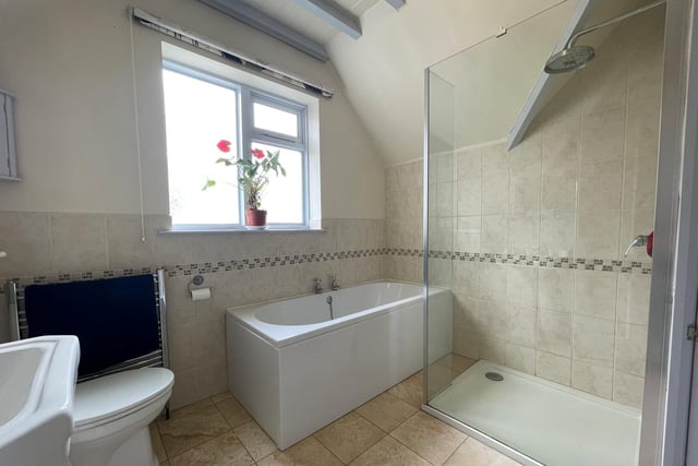 This bathroom has both bath and a walk-in shower cubicle within its suite.