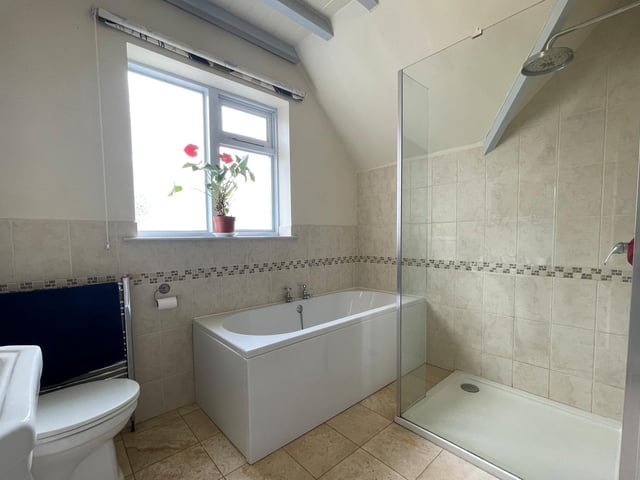 This bathroom has both bath and a walk-in shower cubicle within its suite.